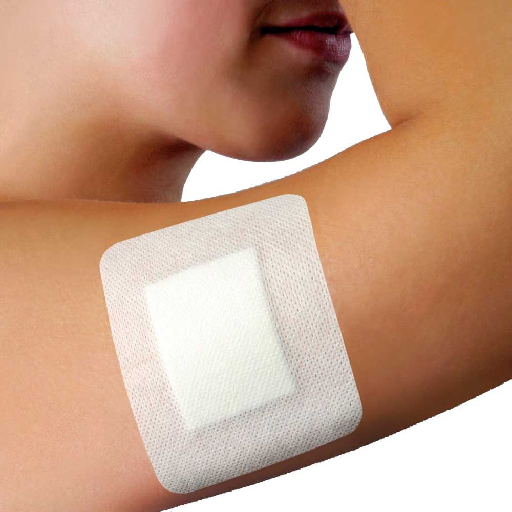 Selbstklebender, steriler Wundverband auf der Haut am Arm, helles Fixierpflaster