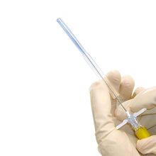 Spinalkanüle mit langer, transparenter Nadelschaftspitze und gelbem Griff, in Handschuhen