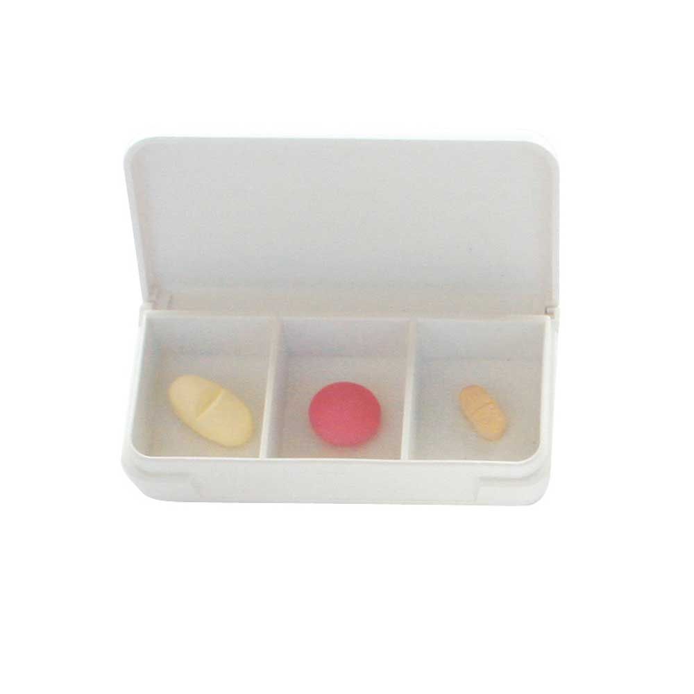 Weiße Tabletten-Dose mit drei Fächern und gelber, roter sowie gelb-beiger Tablette
