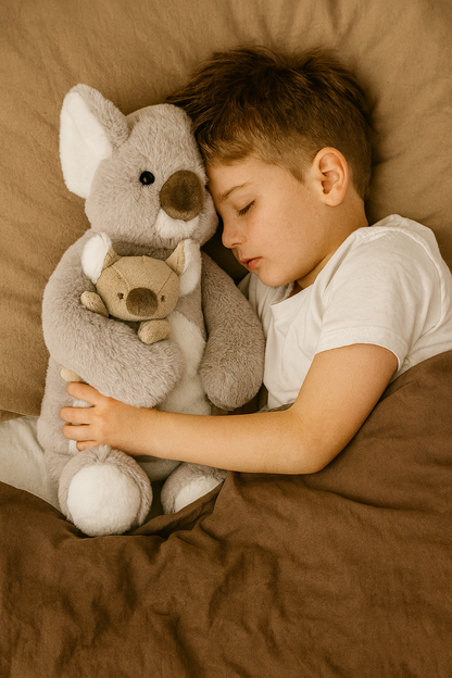 Kind umarmt Plüsch-Koala hellgrau mit kleinem Kuscheltier