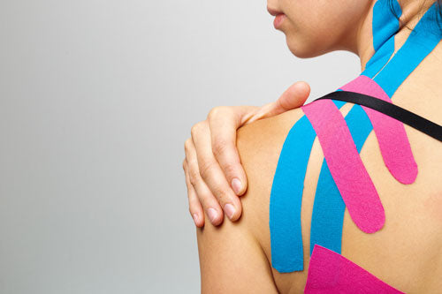 Klassiek sporttape aangebracht op de schouder van een vrouw