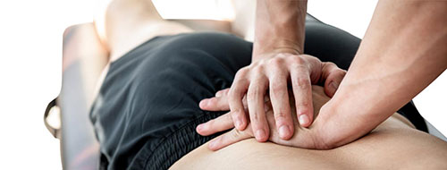 Een persoon tijdens fysiotherapie - rugbandages moeten ter ondersteuning worden aangeschaft
