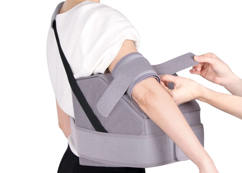 Een patiënte draagt een abductieorthese voor immobilisatie met gespreide arm